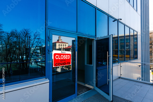 Business center closed due to COVID-19, sign with sorry in door window. Stores, restaurants, offices, other public places temporarily closed during coronavirus pandemic. Economy hit by corona virus