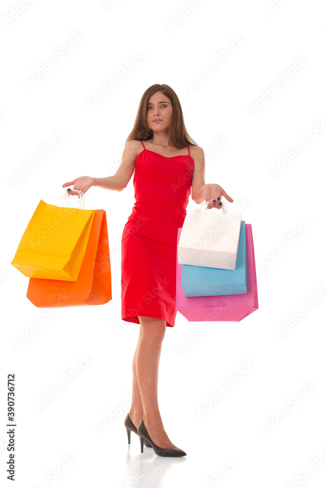 Girl in a dress stands with packages in her hands and looks at the camera in surprise. Beautiful brunette with packages in her hands after shopping. Girl in a dress stands with packages in her hands and looks at the camera in surprise. Beautiful brunette with packages in her hands after shopping.