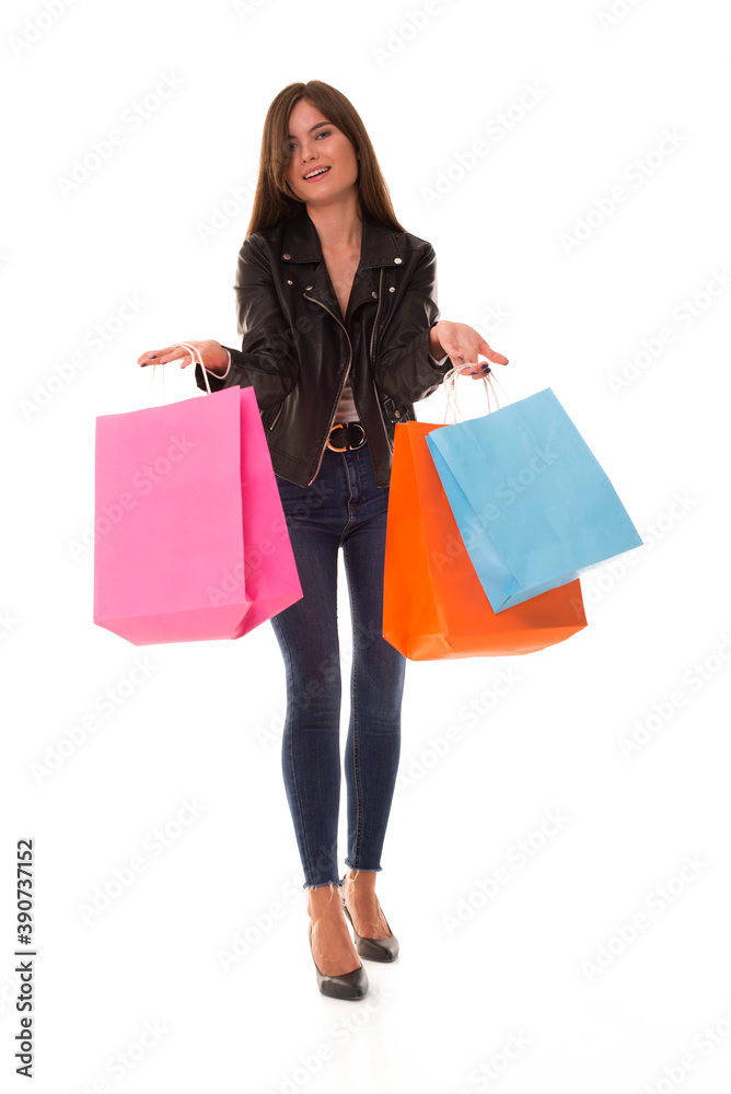 Girl with purchases in her hands smiling at camera. Beautiful girl posing at camera with packages after shopping. Girl with purchases in her hands smiling at camera. Beautiful girl posing at camera with packages after shopping.