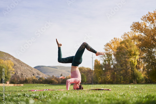 Woman practicing yoga in the park - relaxing in nature