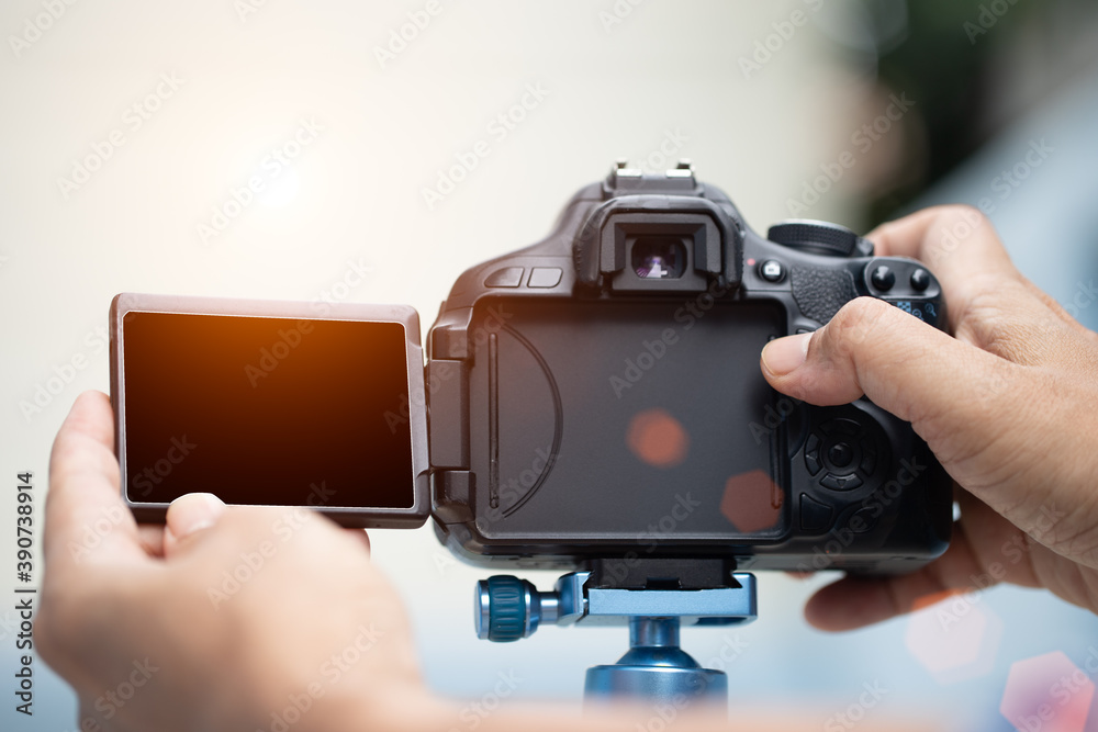 The photographer hand is pressing the shutter with sun light fair, taking picture black the white camera monitor. The photographer hand is pressing the shutter with sun light fair, taking picture black the white camera monitor.