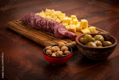 assorted mincemeat on a wooden table. catering, sausage, cheese, olives, peanuts, french fries,
