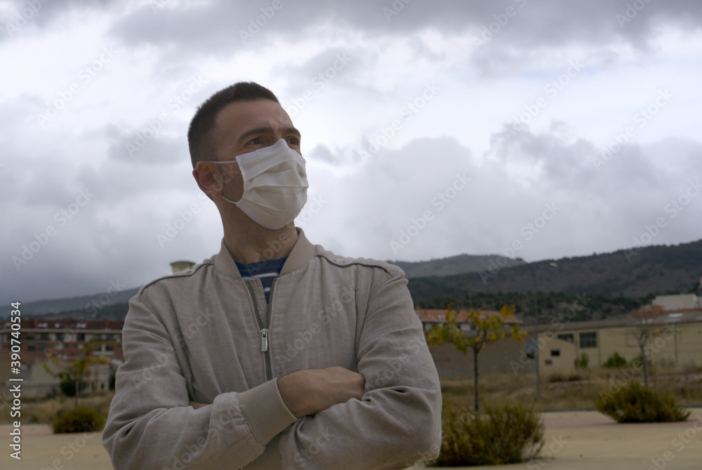 Spanish man wearing reusable facial mask at the street. Concept covid-19 pandemic.