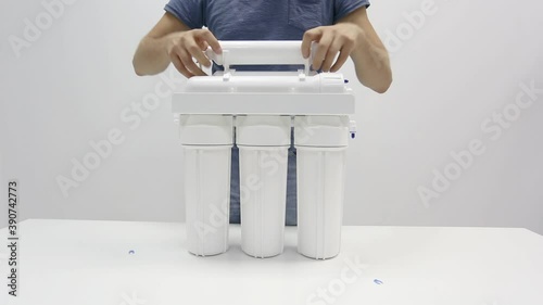 Male hands dismantling small parts from reverse osmosis water filter photo