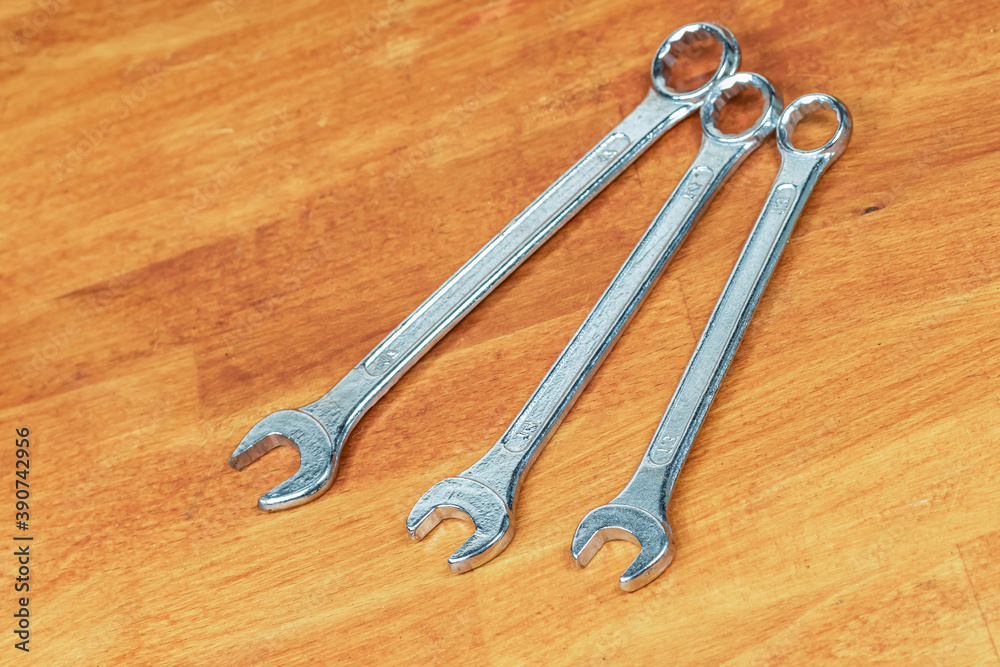 Wrench set different size tools lie in parallel on a wooden background Wrench set different size tools lie in parallel on a wooden background