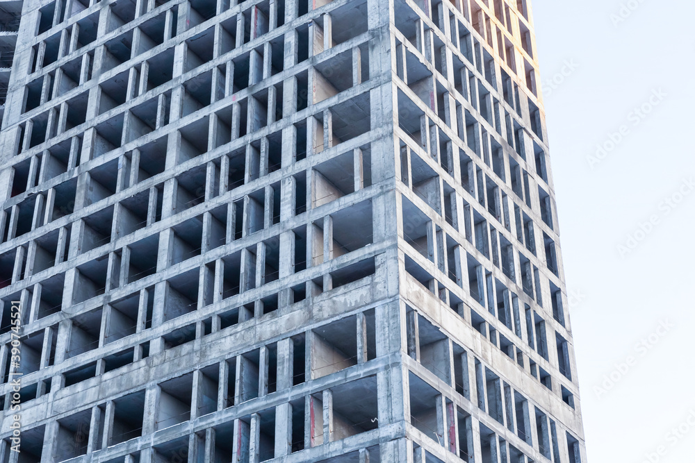 Fototapeta premium tall gray cement building foundation for a residential building close-up against the sky