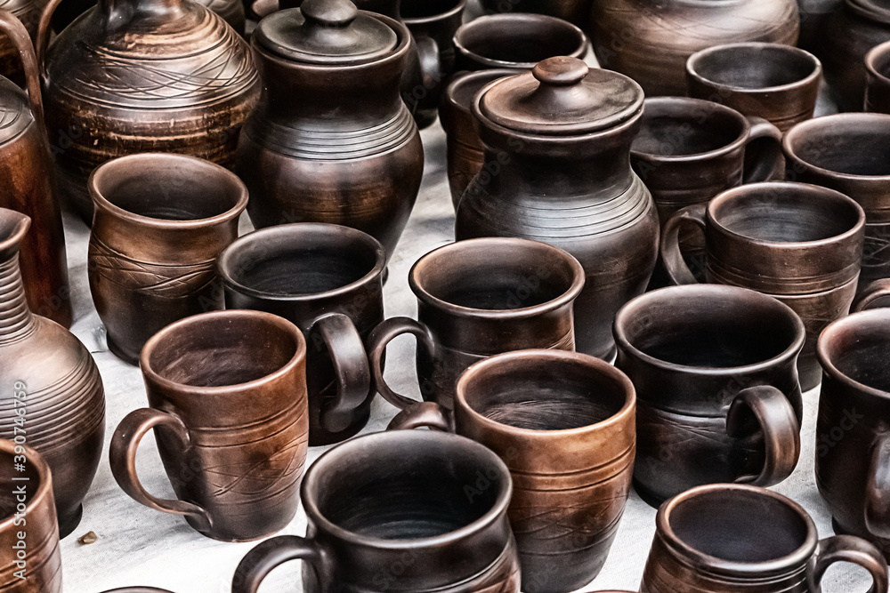 assortment of dark brown cups and a jug made of clay, fair counter traditional dishes assortment of dark brown cups and a jug made of clay, fair counter traditional dishes