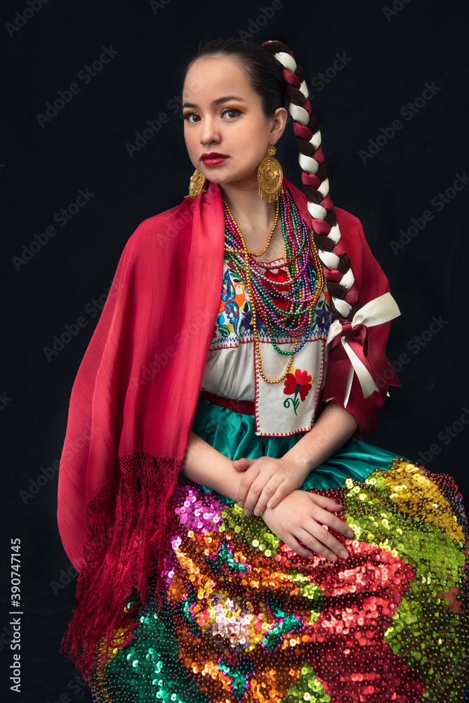 mujer latina vestida de china poblana folklor mexicano de puebla mexico con  trenzas mulitcolores y rebozo rojo, collares de cuentas y falda bordada con  lentejuelas y moños Stock Photo | Adobe Stock