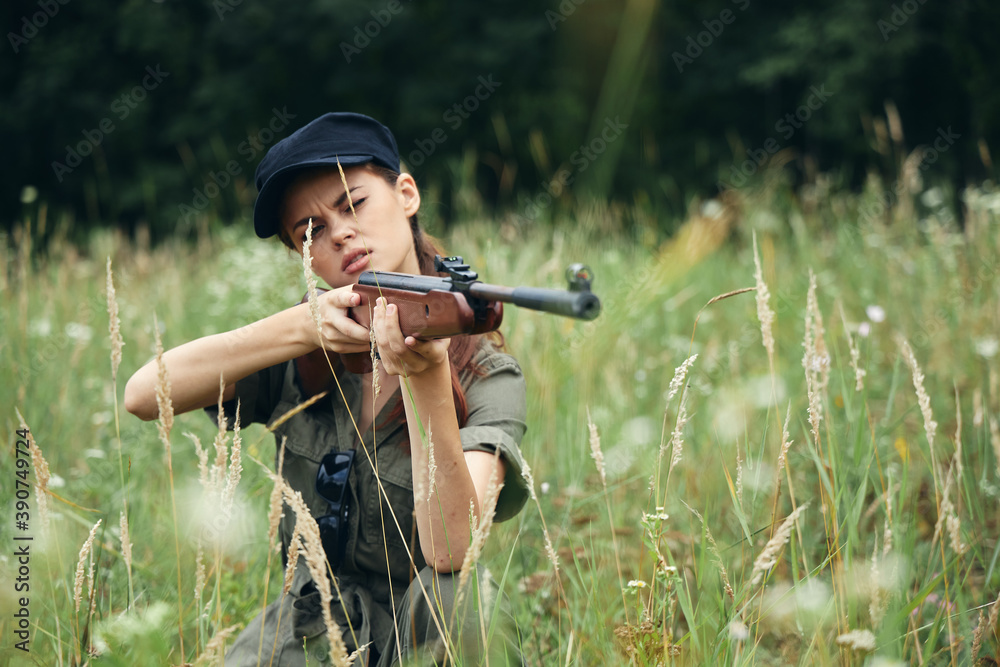 Fototapeta premium Military woman Gun in hand is a hunting lifestyle green overalls 