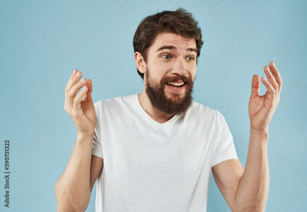 Handsome man with beard on blue background white t-shirt portrait cropped view Handsome man with beard on blue background white t-shirt portrait cropped view