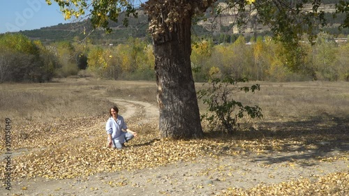 Woman throwing up autumn leaves in the park
