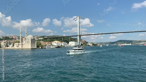 Footage of luxury yacht passing on Bosphorus in Istanbul. Historical landmark called 