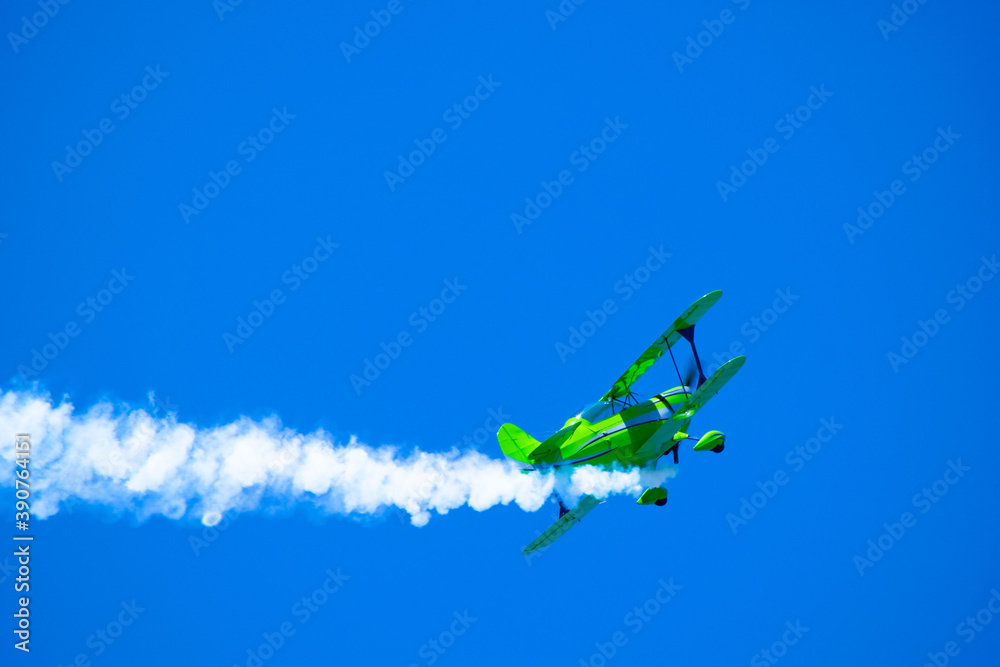 stunt plane  performing air acrobatics in the blue sky - obrazy, fototapety, plakaty 
