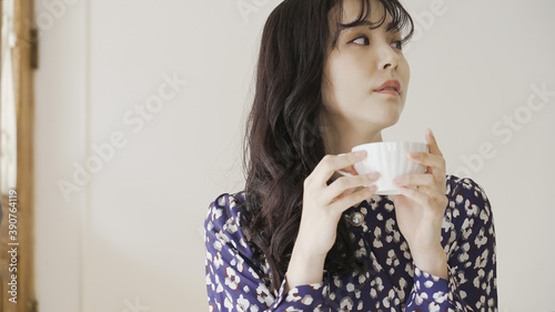 カフェで飲み物を飲む若い女性