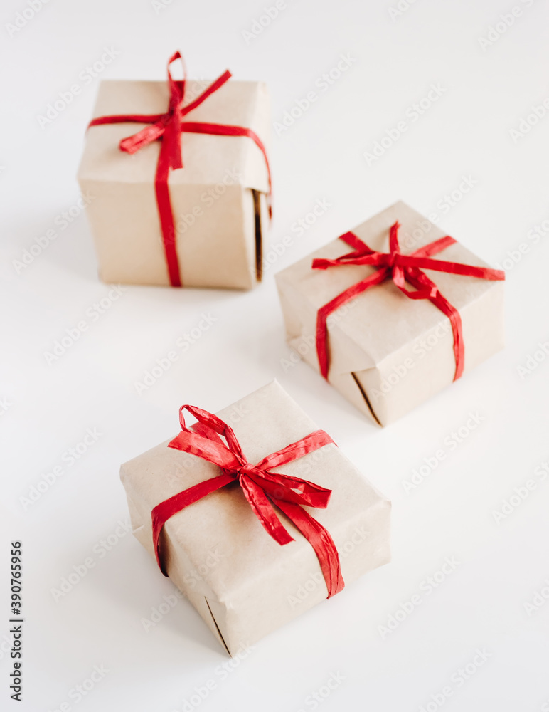 Fototapeta premium Gift boxes made from craft paper with red ribbon on white background