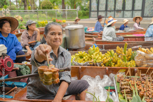 Damnoen Saduak Floating Market or Amphawa. Local people sell fruits, traditional food on boats in canal, Ratchaburi District, Thailand. Famous Asian tourist attraction destination. Festival in Asia. photo