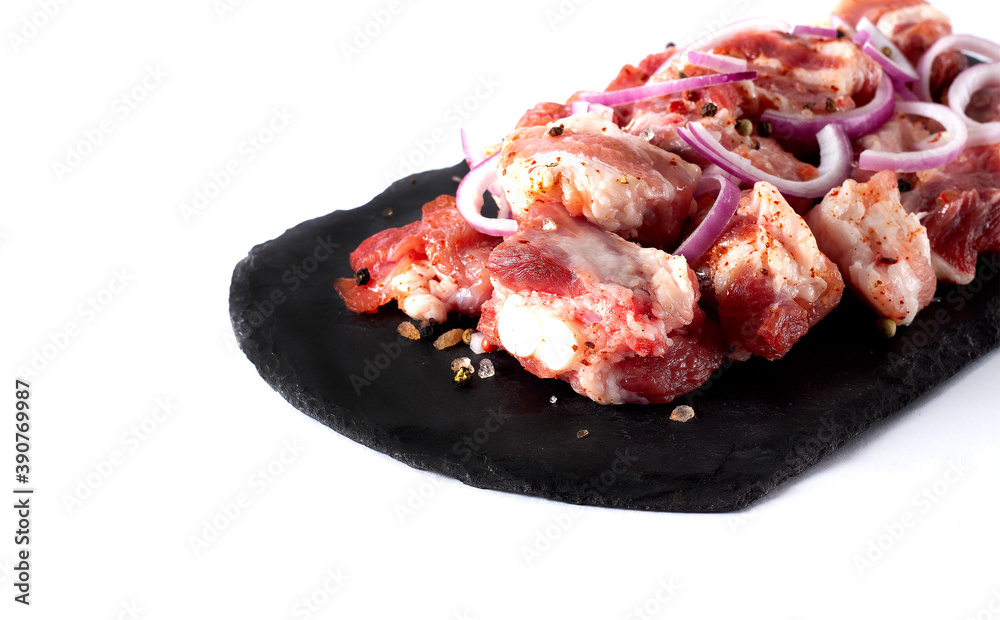 Pork, sliced, raw, with spices, horizontal, on a white plate, copy spaspce,