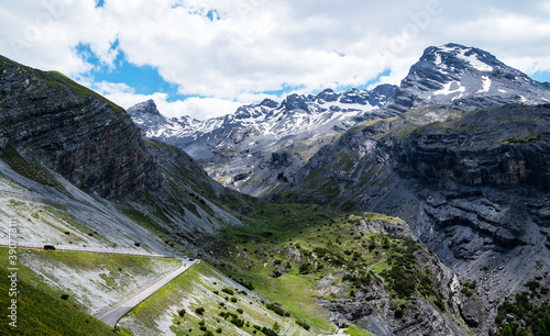 Summer Stelvio pass with alpine road and snow on slope. Panoramic view of the over the alps between Lombardy and Trentino. Color image. Italian mountains.