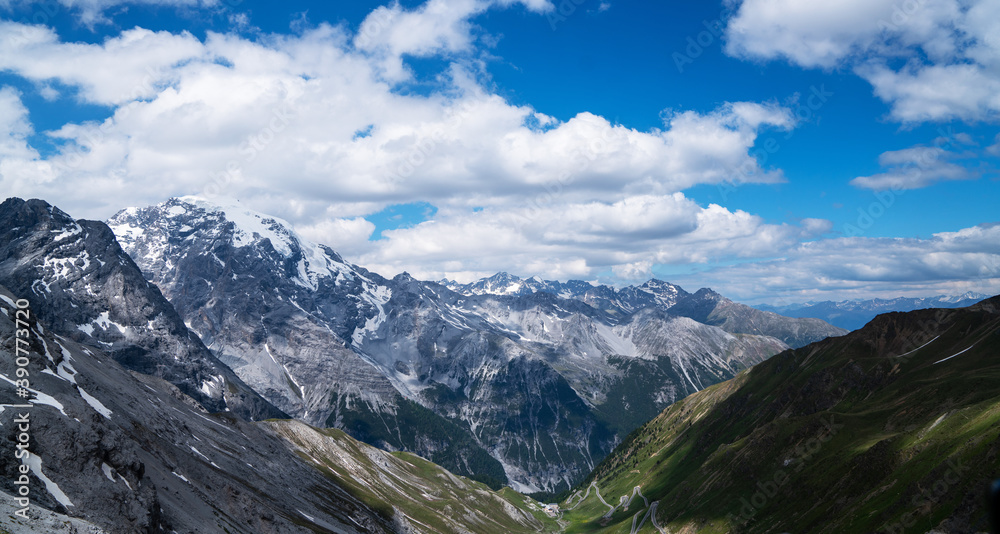 Summer Stelvio pass with alpine road and snow on slope. Panoramic view of the over the alps between Lombardy and Trentino. Color image. Italian mountains.