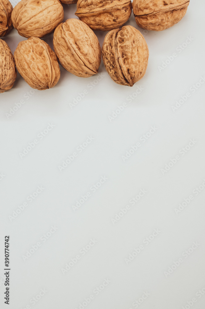 Fototapeta Vertical shot of walnuts isolated on a white background