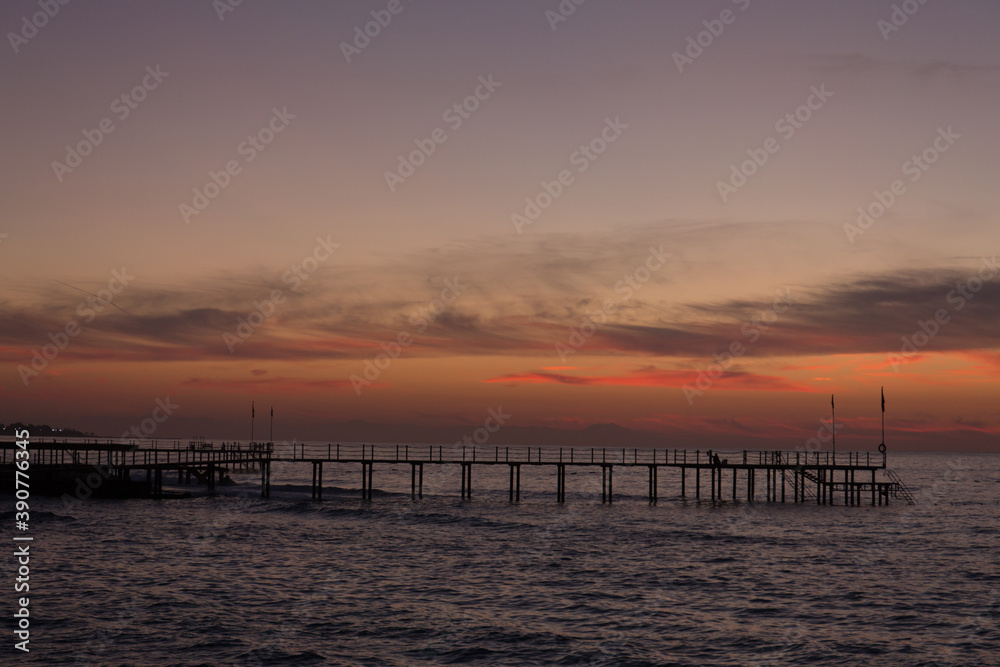 Beautiful sunset on the sea and the pier.