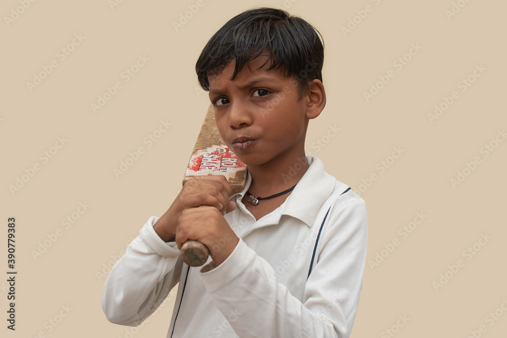 A boy in cricket uniform and holding bat A boy in cricket uniform and holding bat