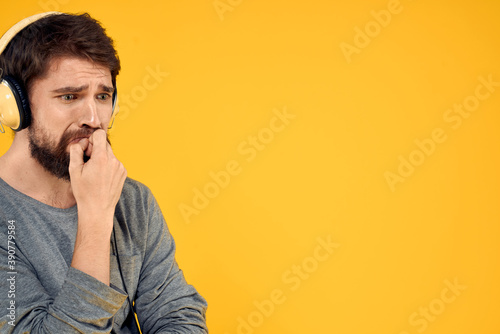 Man in headphones listens to music technology lifestyle fun people yellow background © SHOTPRIME STUDIO