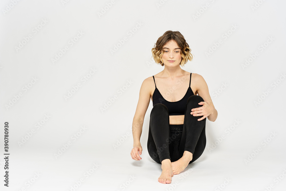 Woman in leggings meditate in a light room with her legs crossed yoga asana Woman in leggings meditate in a light room with her legs crossed yoga asana