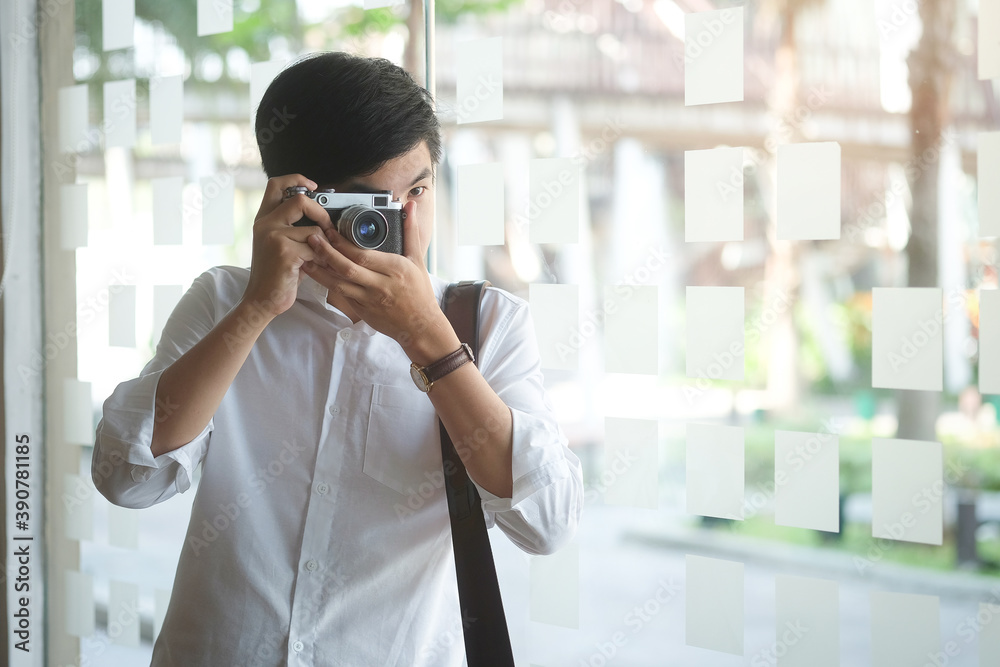 A confident man photographer with a camera taking pictures photo shooting in studio. A confident man photographer with a camera taking pictures photo shooting in studio.