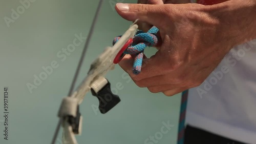 a man on a sunny day ties a rope on a ship checking its strength
