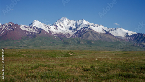 View of the snow-capped Trans-Alay mountain range from the road between Sary Tash and high altitude Kyzyl Art pass in southern Kyrgyzstan leading to the border with Tajikistan