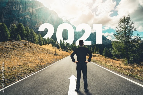 The 2021 New Year journey and future vision concept . Businessman traveling on highway road leading forward to happy new year celebration in beginning of 2021 for fresh and successful start .