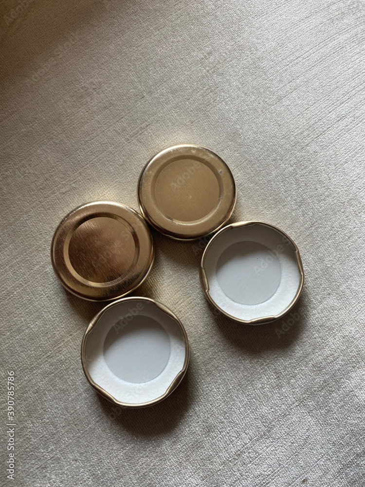 Set of four bottle caps golden and white in colour with two upside down and two straight Set of four bottle caps golden and white in colour with two upside down and two straight