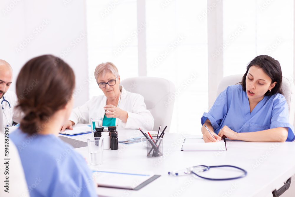 Doctors having a medical discussion with her staff during team meeting. Clinic expert therapist talking with colleagues about disease, medicine professional. Doctors having a medical discussion with her staff during team meeting. Clinic expert therapist talking with colleagues about disease, medicine professional.