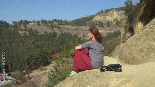 Girl sitting on a sandy mountain and reciting mantras with her lips