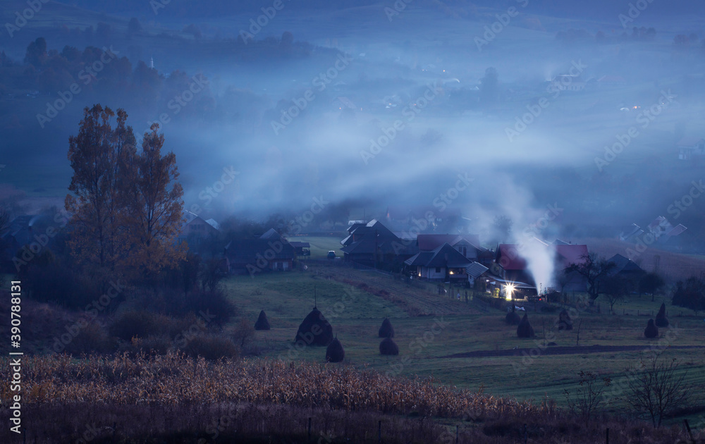 Village at night in autumn fog and smoke.