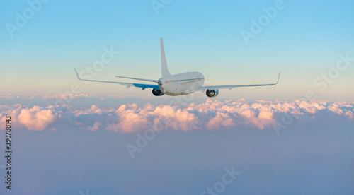 White passenger airplane over the clouds - Travel by air transport