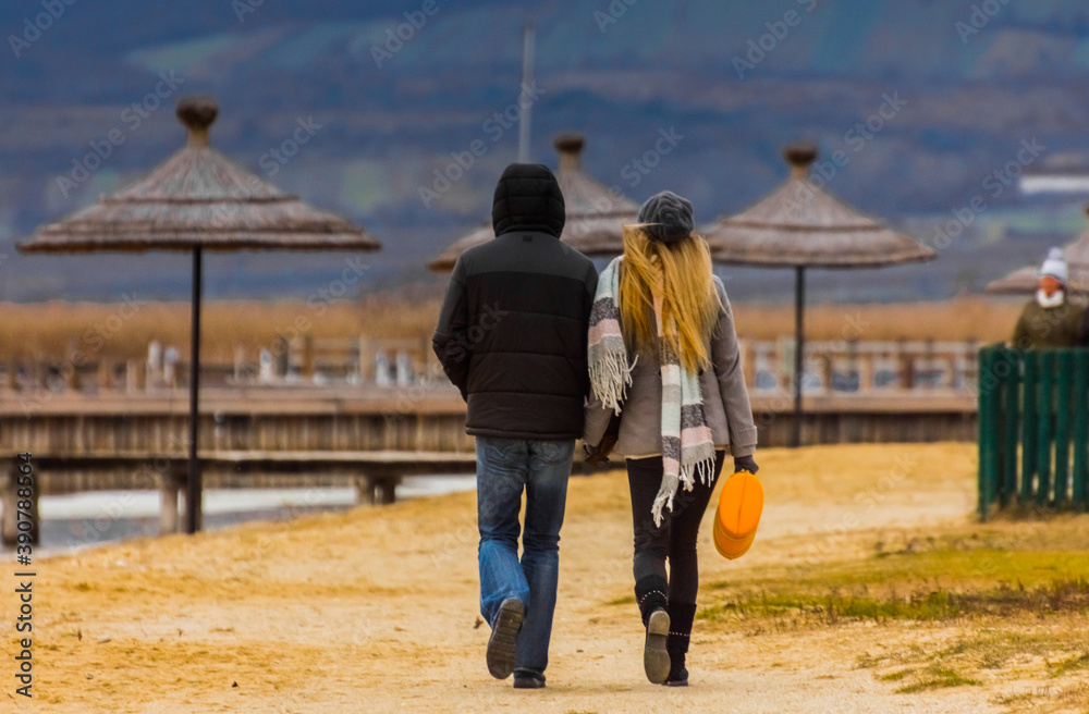 man and woman while walking at the lake in autumn man and woman while walking at the lake in autumn