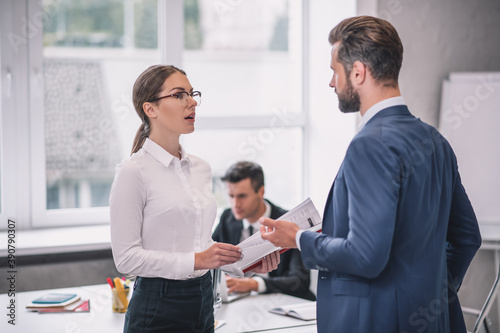 Woman with glasses and bearded man standing talking