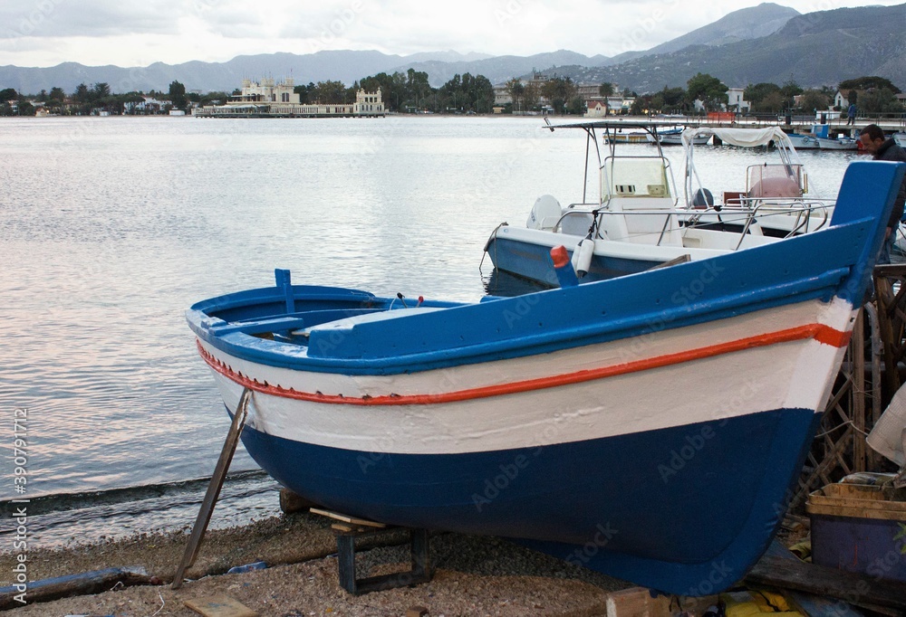evocative image of fishing boat at the beach by the sea at sunset with bad weather evocative image of fishing boat at the beach by the sea at sunset with bad weather