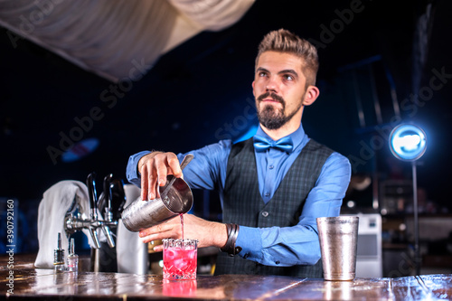 Bartender concocts a cocktail in the public house photo