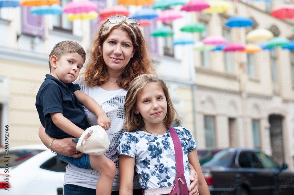 Fototapeta premium The woman travels with her children to other cities of her country, they communicate a lot, establish relationships, it is clear that they are a little tired but happy