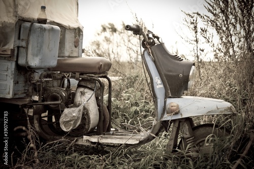 Fotografie An old truck scooter standing in field in summer