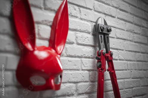 creative design of refractory brick wall with the Bunny mask and the bolt cutters with a tight chain