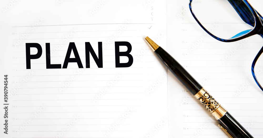 In the diary, the text is PLAN B, there is a pen and glasses nearby. In the diary, the text is PLAN B, there is a pen and glasses nearby.