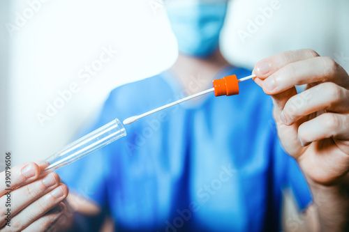 Fotografi Medico o infermiere fa il test del tampone salivare nella provetta