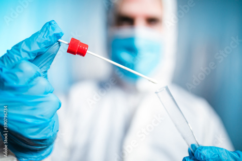 Medico o infermiere con tuta bianca covid fa il test del tampone salivare per il coronavirus covid 19