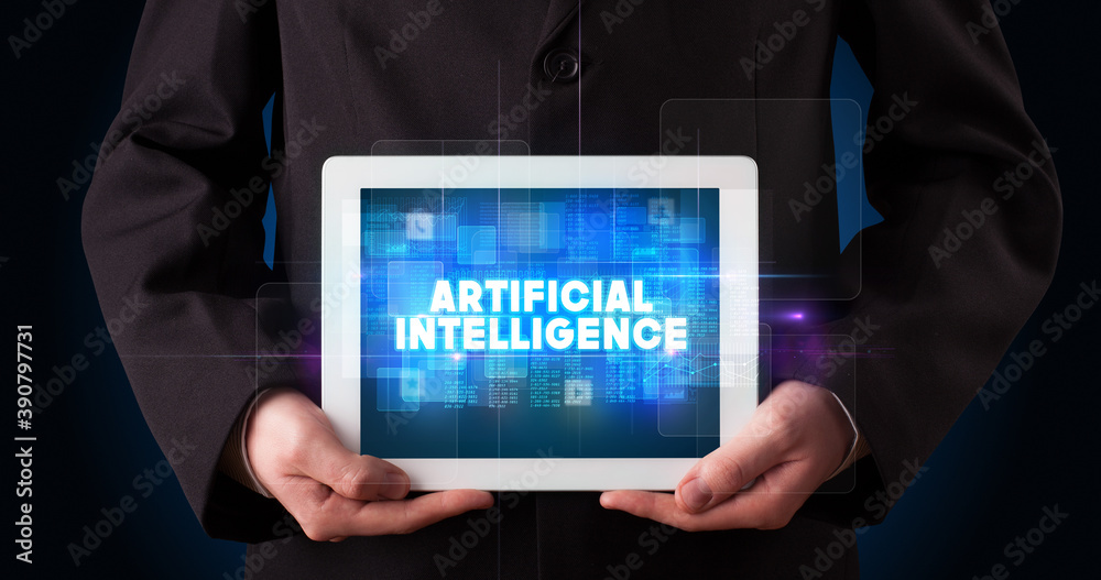Young business person working on tablet and shows the inscription: ARTIFICIAL INTELLIGENCE Young business person working on tablet and shows the inscription: ARTIFICIAL INTELLIGENCE
