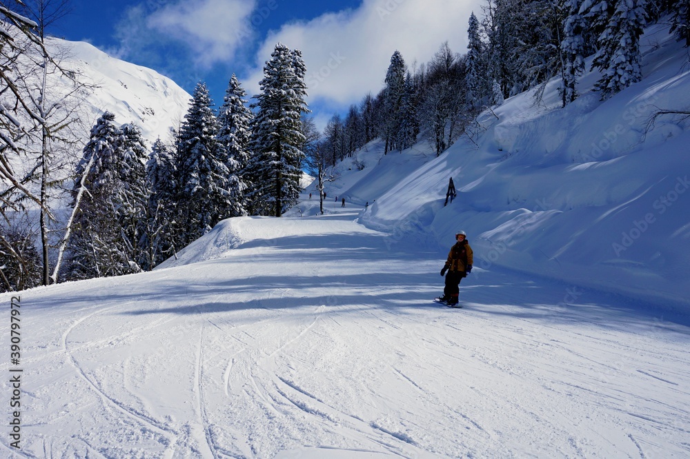 Wintergebirgslandschaft, blauer Himmel, schneebedeckte Gipfel, Skipisten.