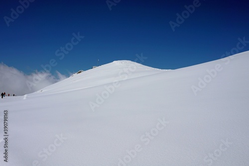 Wintergebirgslandschaft, blauer Himmel, schneebedeckte Gipfel, Skipisten. © Михаил Рафибеков